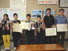 メダルと賞状を持ち記念撮影をする学生たちの写真