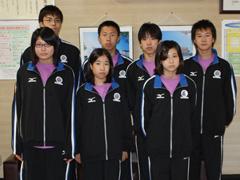 前後二列でユニフォーム姿で記念撮影をする水泳競技大会出場者の方々の写真