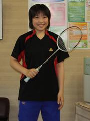 バドミントンのラケットを胸に掲げて記念撮影をする水間里美選手の写真