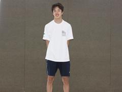 白いTシャツを着た男性が立っている写真