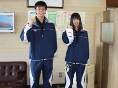 ガッツポーズを取る全国高校水泳大会出場の男子女子それぞれ一人ずつの高校3年生と教育長の写真