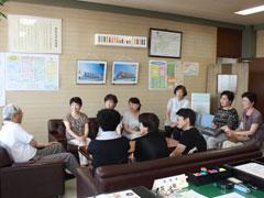 教育長を表敬訪問する家庭婦人たちのコーラスグループコールアイリスのメンバーたちの写真