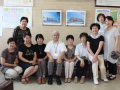 教育長を真ん中にポーズを取るコーラスグループアイリスのメンバーたちの写真
