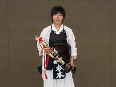 白い剣道着を着てトロフィーを持っている女性の写真