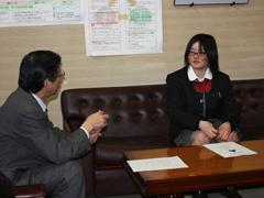 制服姿の女子選手がスーツ姿の教育長と談笑している写真