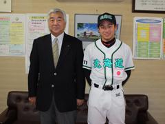 スーツを着た男性とユニフォームを着た男性が並んで立っている写真