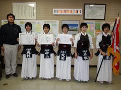 白い胴衣の剣道部員5名とその左に黒いジャケットの男性が写っている写真