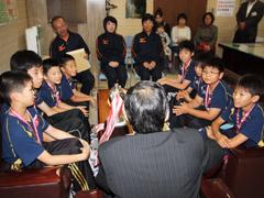 教育長を囲み談笑するユニフォームを着た児童たちの写真