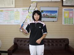 ユニフォームを着た女性がラケットを構えている写真
