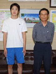 体操服で記念撮影する男子生徒とめがねをかけた男性の写真