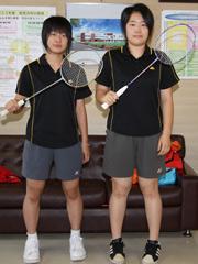 二人並んでバドミントンラケットを構える女子生徒の写真