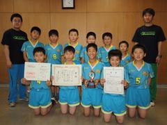 青いユニフォーム姿の小学生男子達が賞状を両手で持って並んで撮影されている写真
