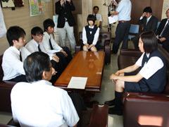 制服姿の学生達が机向かいに教育長と対談している写真