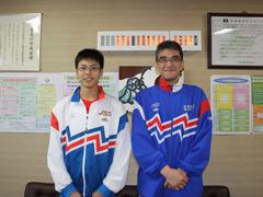 白いジャージ姿の選手と青いジャージ姿の男性の写真