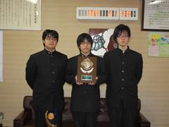 トロフィーを手に持つ3名の男子高校生の写真
