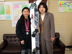 スノーボードを手にポーズを取る女子小学生と女性の写真