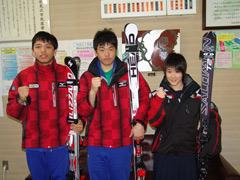 赤いスキーウエアに青いパンツの男子中学生選手2人と3人揃ってスキー板を抱えた女子中学生選手の写真