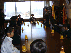 岩見沢市の教育長を訪問しテーブルを囲むようにして椅子に座っている「ほろむい太鼓同志会」の皆さんを撮影した写真