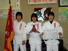 賞状や優勝旗を持っている光陵中学校女子柔道部の玉置 桃さん、藤嶋 奈緒さん、伊藤 なごみさんの集合写真
