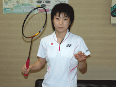 白いユニフォームを着た左手にバドミントンのラケットを持った東野有紗さんの写真