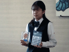 第24回全道高等学校簿記コンクールで第3位となり、右手に電卓、左手に記念品を持っている南部由貴さんの写真