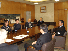 岩見沢市教育長を訪問し、ソファに腰かけている石津 幸恵さんと教育委員の役員たちが映っている写真