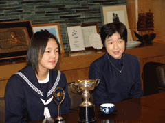 テーブルの上にある準優勝トロフィーと石津 幸恵さんと顧問の先生が映っている写真