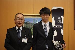 左に教育長、右にスノーボードを持った平野さんが並んだ写真