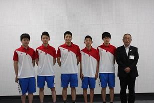 右からスーツを着た男性と、5人のユニフォームを着た男子生徒が並んでいる写真