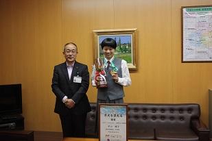 陸上100メートル走で優勝した女史生徒が教育長と記念写真を撮った際の写真