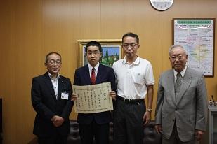 右から、グレーのスーツを着た男性と、白いシャツを着た男性と、青いスーツを着た男性と、黒いスーツを着た男性が並んでいる写真