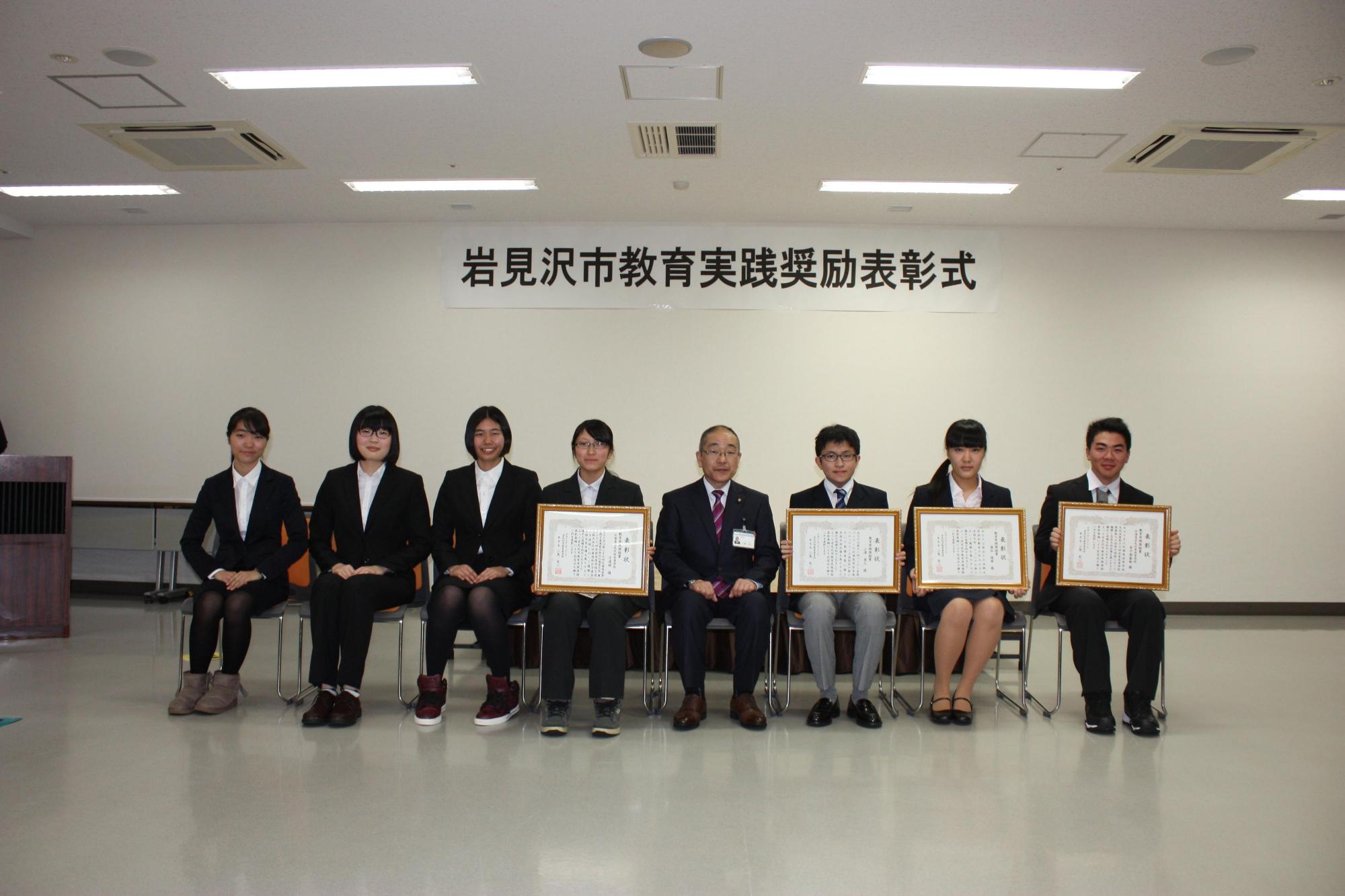賞状を持つ4名の受賞者たちと賞状を持ってない4名の人たちの写真