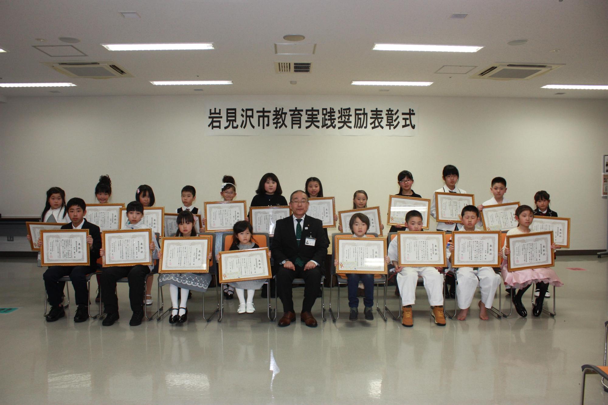 小学生ぐらいの受賞者たちが賞状を持っている写真