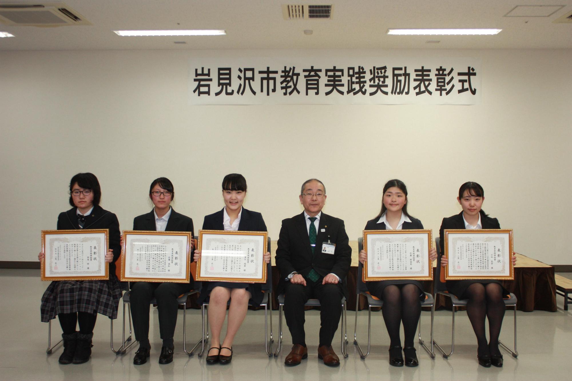 スーツや制服を着た女性達の受賞者の集合写真