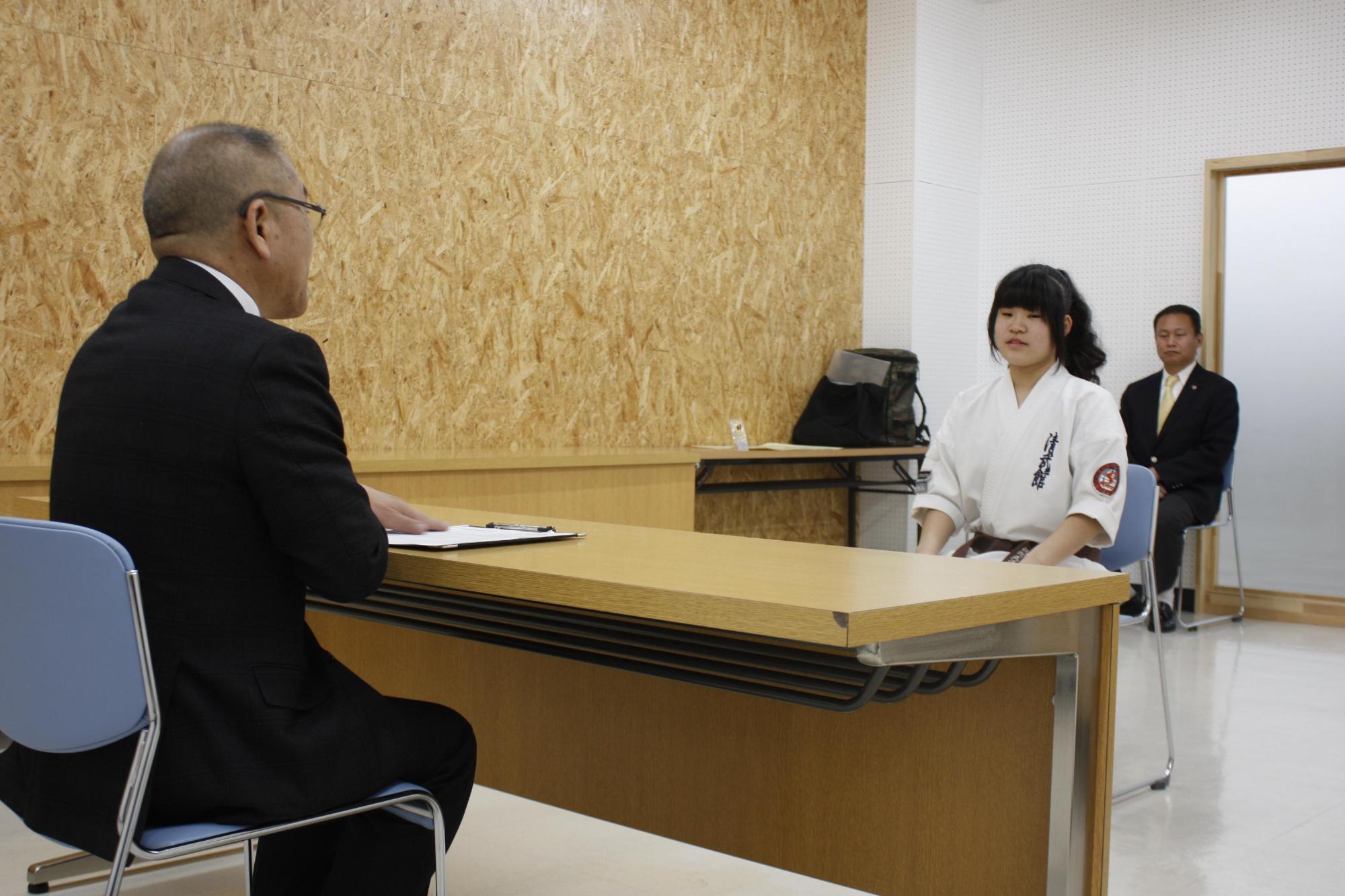 岩見沢市の教育長を訪問し、教育長と談笑している菊地 咲さんを撮影した写真