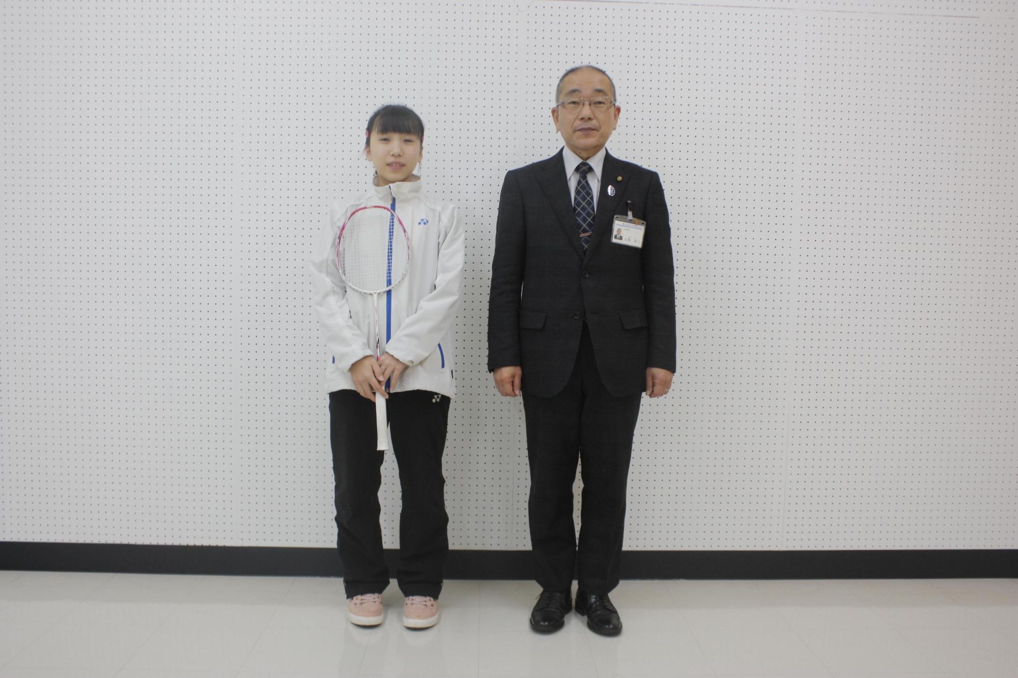 バトミントンのラケットを持っている橋本さんと教育長が並んでの記念撮影の写真