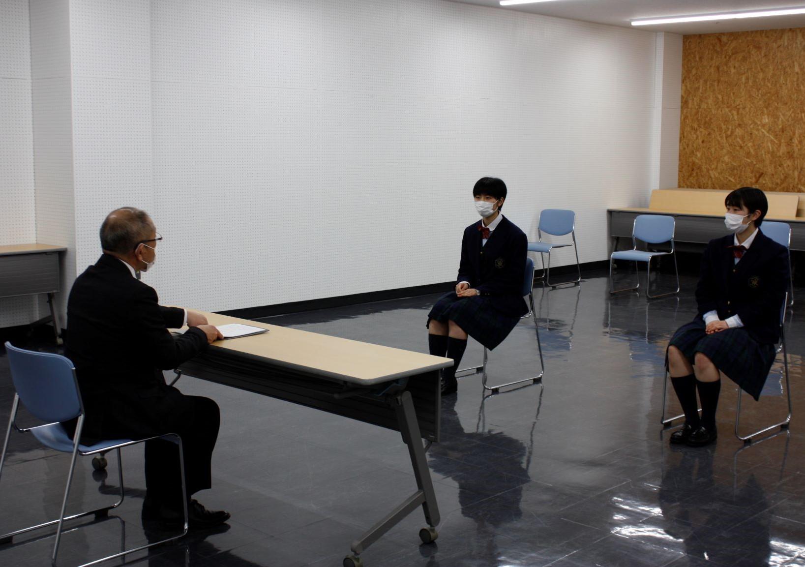 教育長と選手2名が歓談している様子の写真