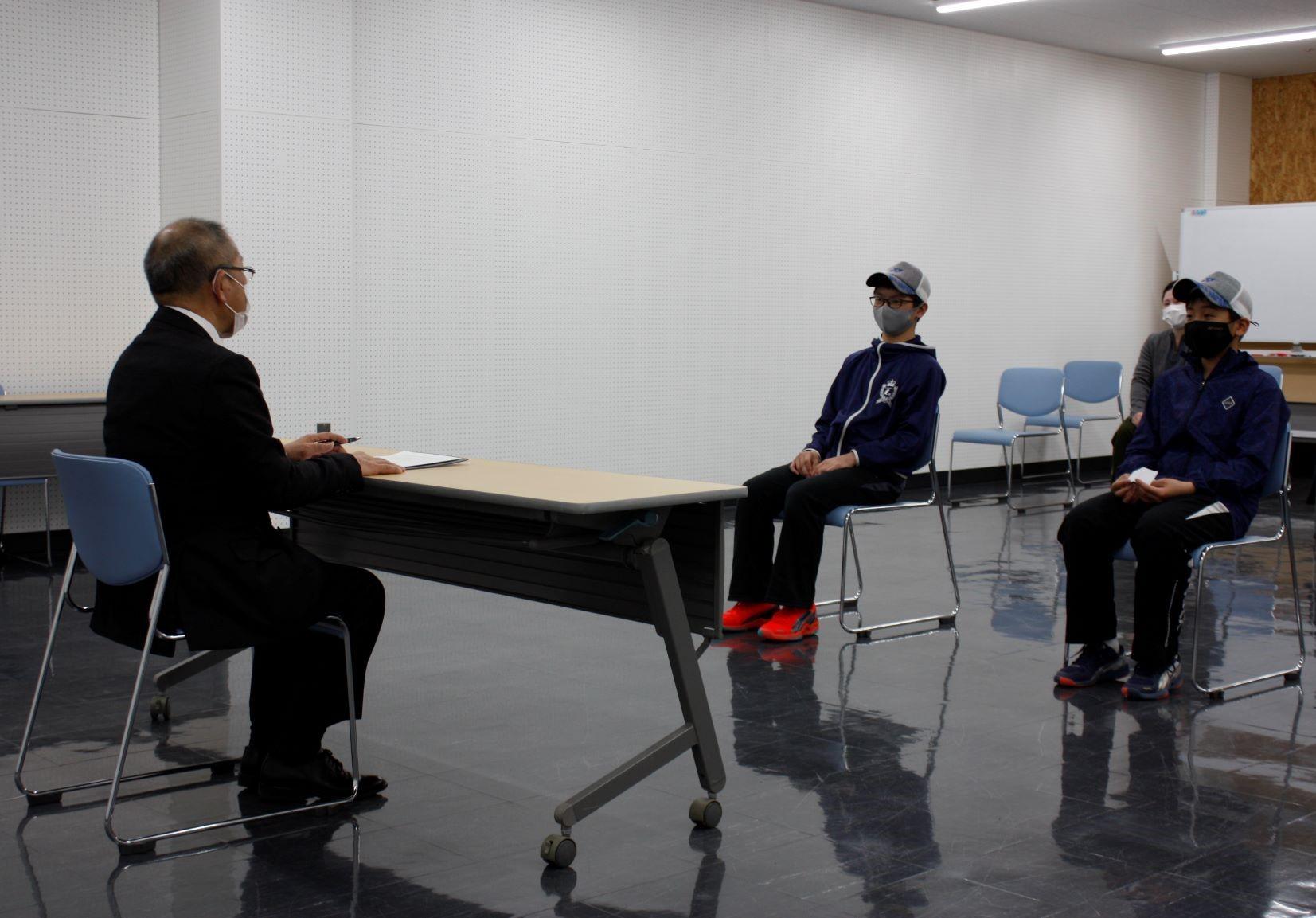 選手2名と教育長が歓談している様子の写真