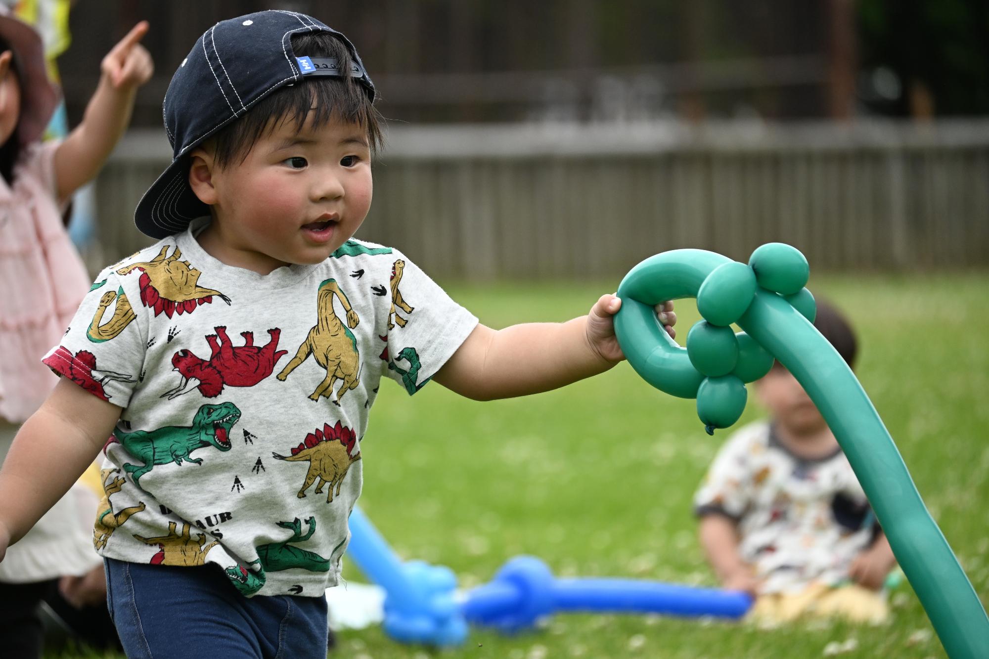 風船で作った緑色の剣で遊ぶ男の子
