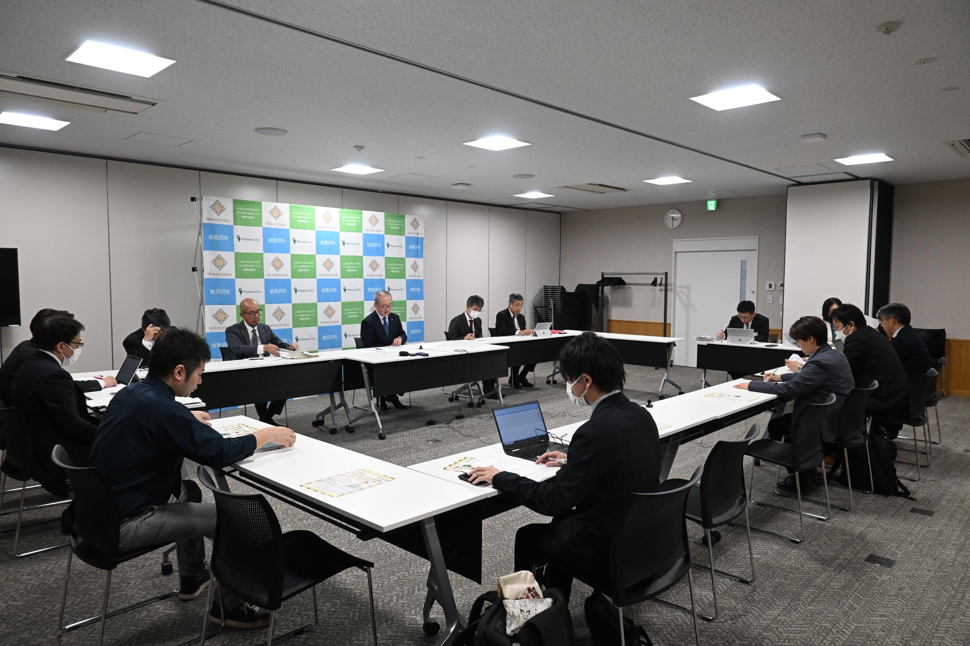 市長ほか市職員と記者がロの字型に座っている記者懇談会会場全体の様子の画像