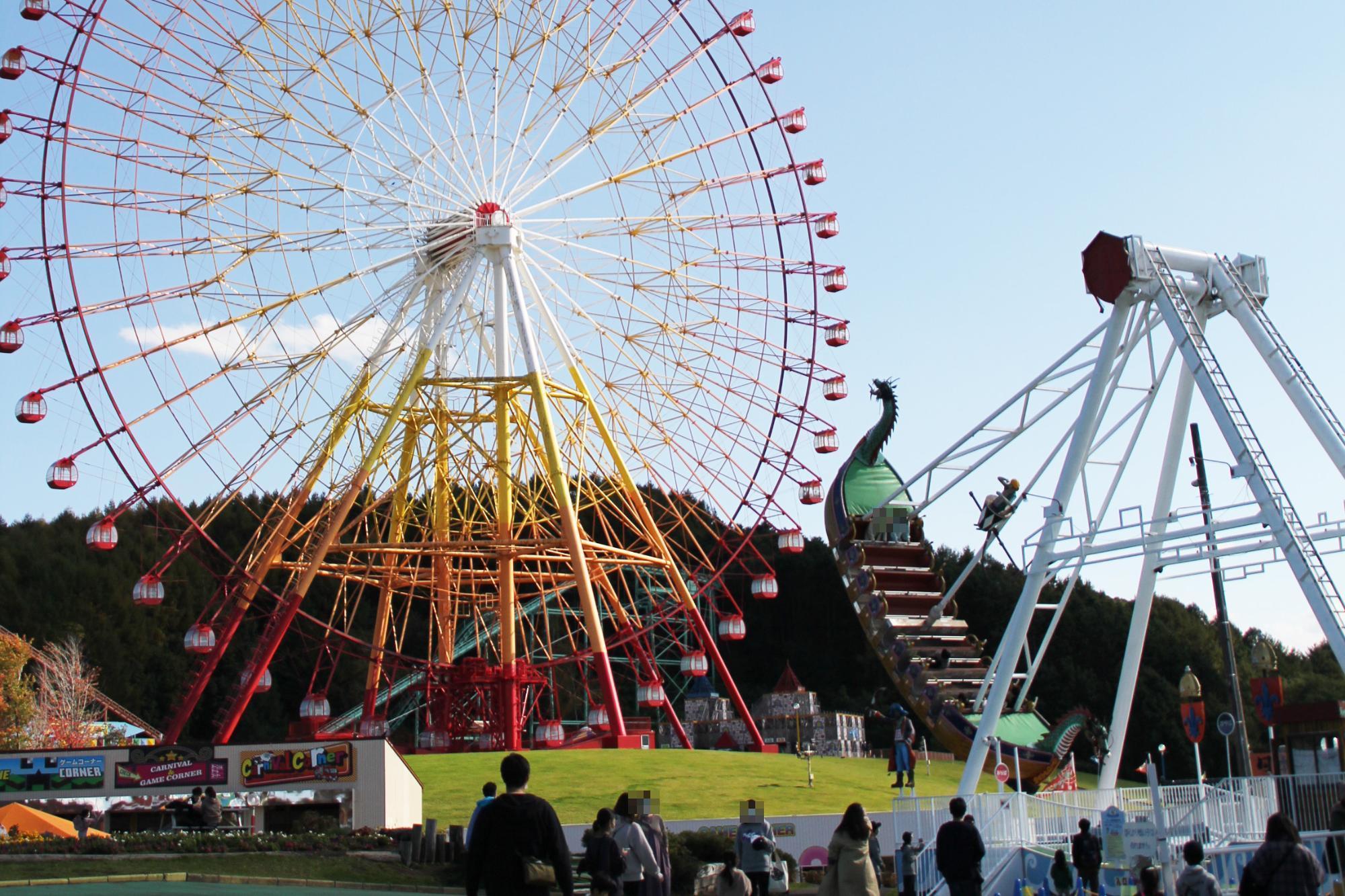 大観覧車と遊具が写った、北海道グリーンランド遊園地の園内の写真