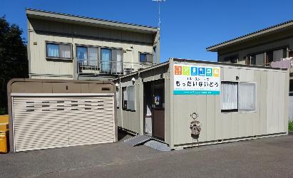 住宅地に位置する、リユースショップもったいないどう（プレハブ小屋）の外観の写真
