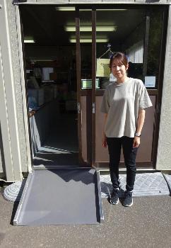 リユースショップもったいないどうの入口に設置されたアルミ製スロープとその横に店員が立っている写真