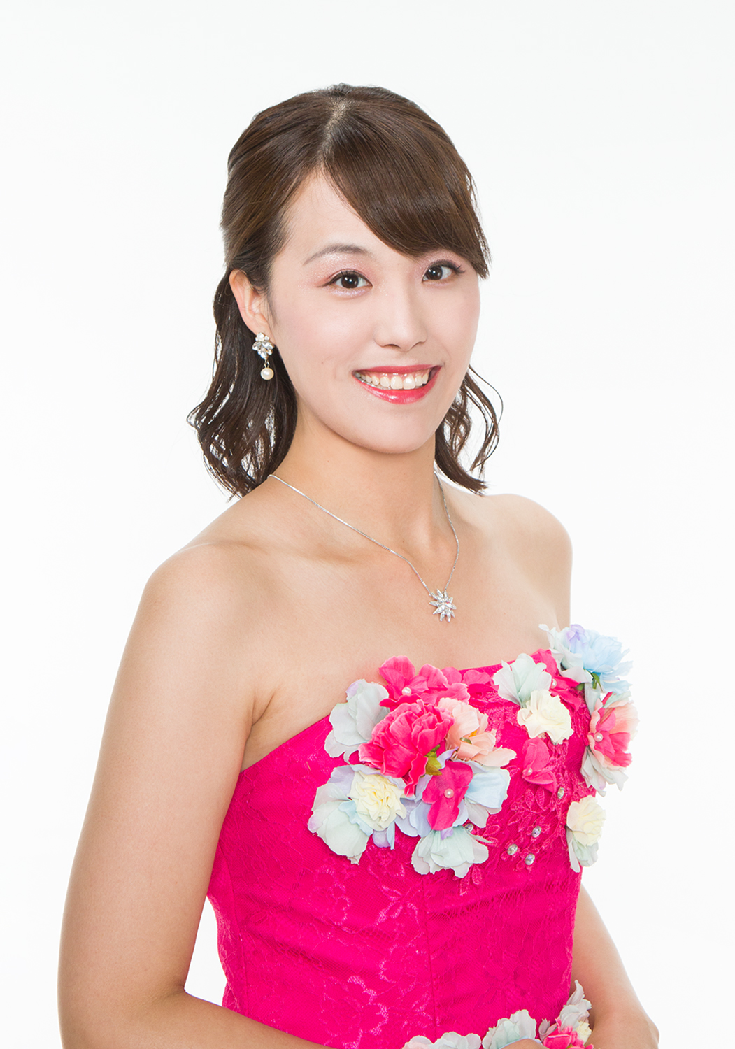 花の刺繍で飾られたピンクのドレスを身に纏う川辺 美穂さんの写真