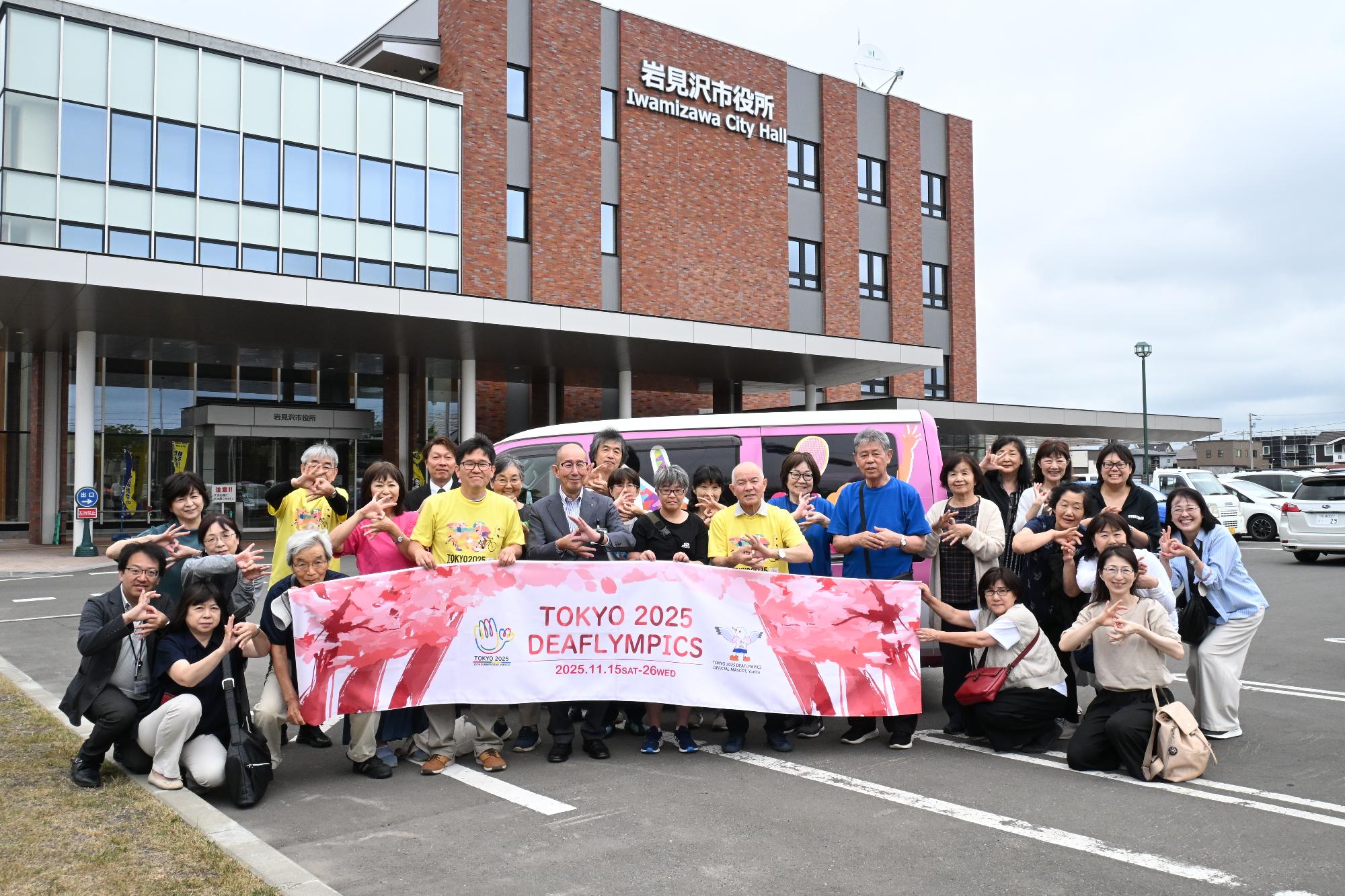 北海道ろうあ連盟の方と集まった皆さんで横断幕を持ち、キャラバンカーの前で記念撮影した画像