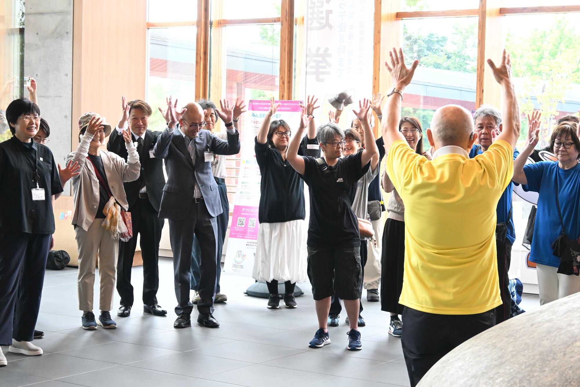 市役所エントランスホールで北海道ろうあ連盟理事長がデフリンピックPR活動を行う様子の画像