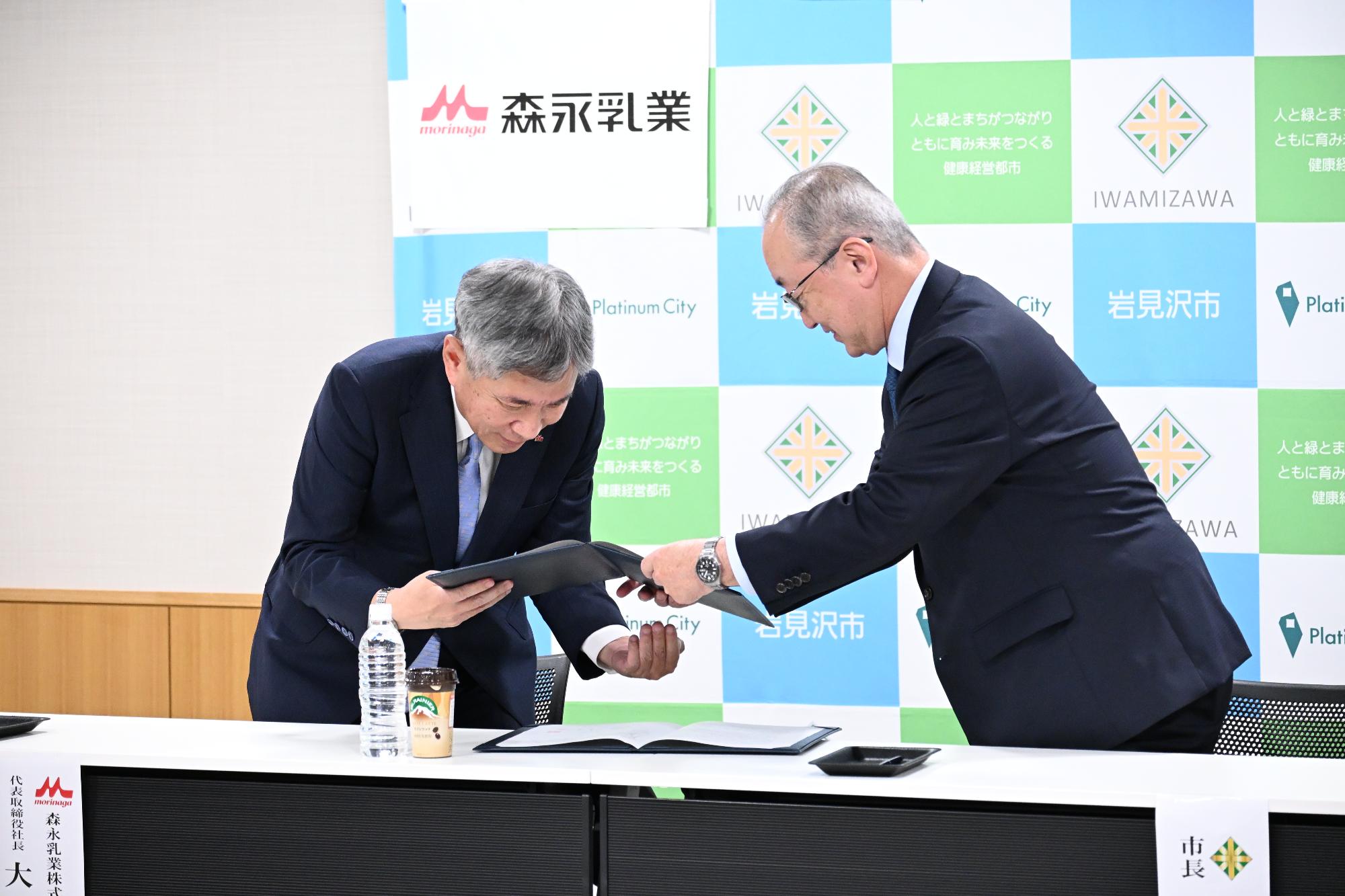 大貫社長と松野市長が協定書に相互署名を行っています。