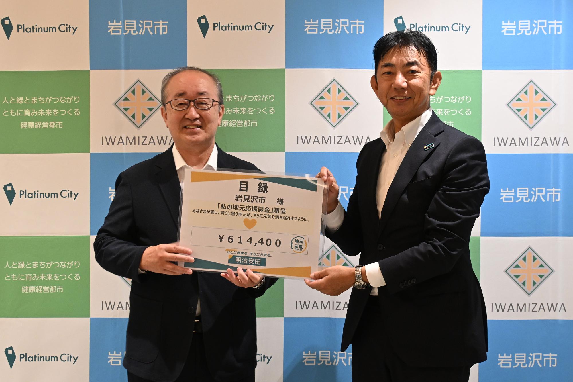 松野市長（左）が福岡市場統括部長（右）から目録の贈呈を受けました。