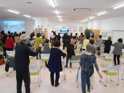 椅子の横に立って体を動かしている様子