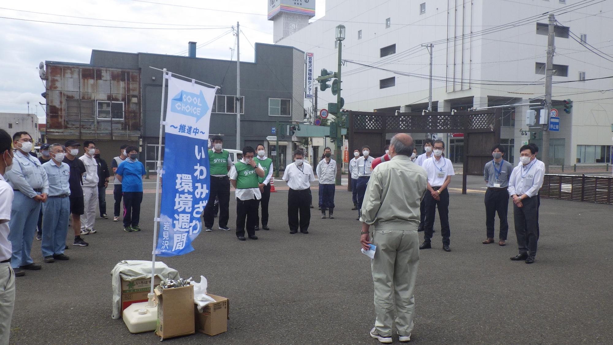 まちなか環境美化活動の参加者が、であえ―る前の広場でゴミ拾いについて説明受けている様子